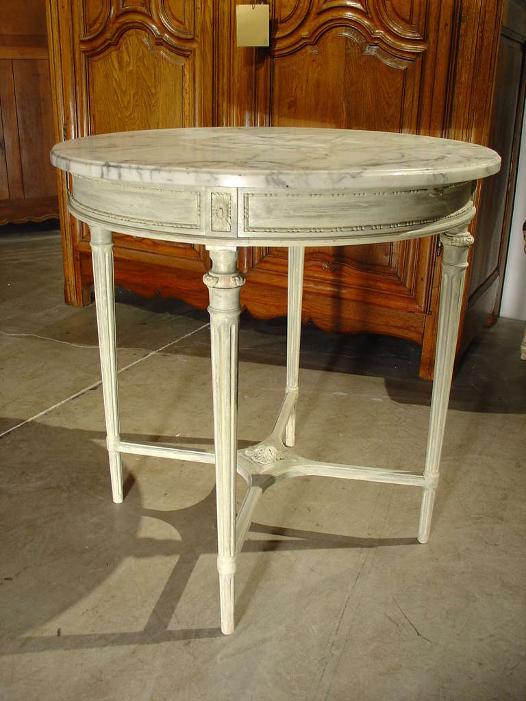 This antique French Louis XVI style round, painted side table with carrera marble is perfect for a table in between two chairs or at the end of a settee or sofa.  It could also be a substitute for a pedestal holding a wonderful piece of statuary or