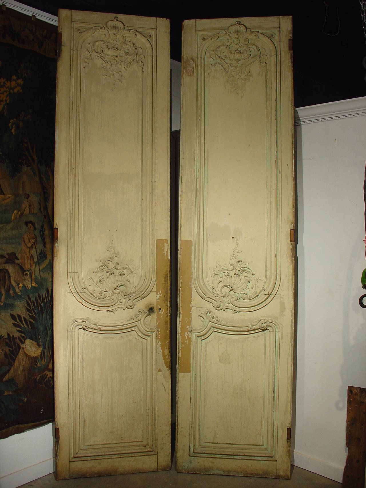 These elegant and tall Regence style doors are from the early 1800’s and have all the attributes of the Regence period--elegance without ostentation. The European oak was left natural on one side but the other side has old French cream/green paint.