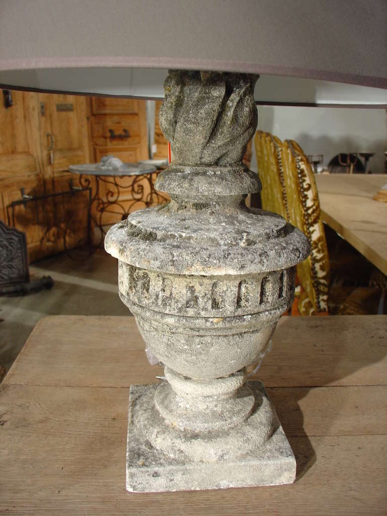 Stone finial bases are 19th century; French electrification

This is a wonderful pair of antique French stone urns that have been made into table lamps.  There is a classic flame finial atop the urns and the shades were made recently in France.