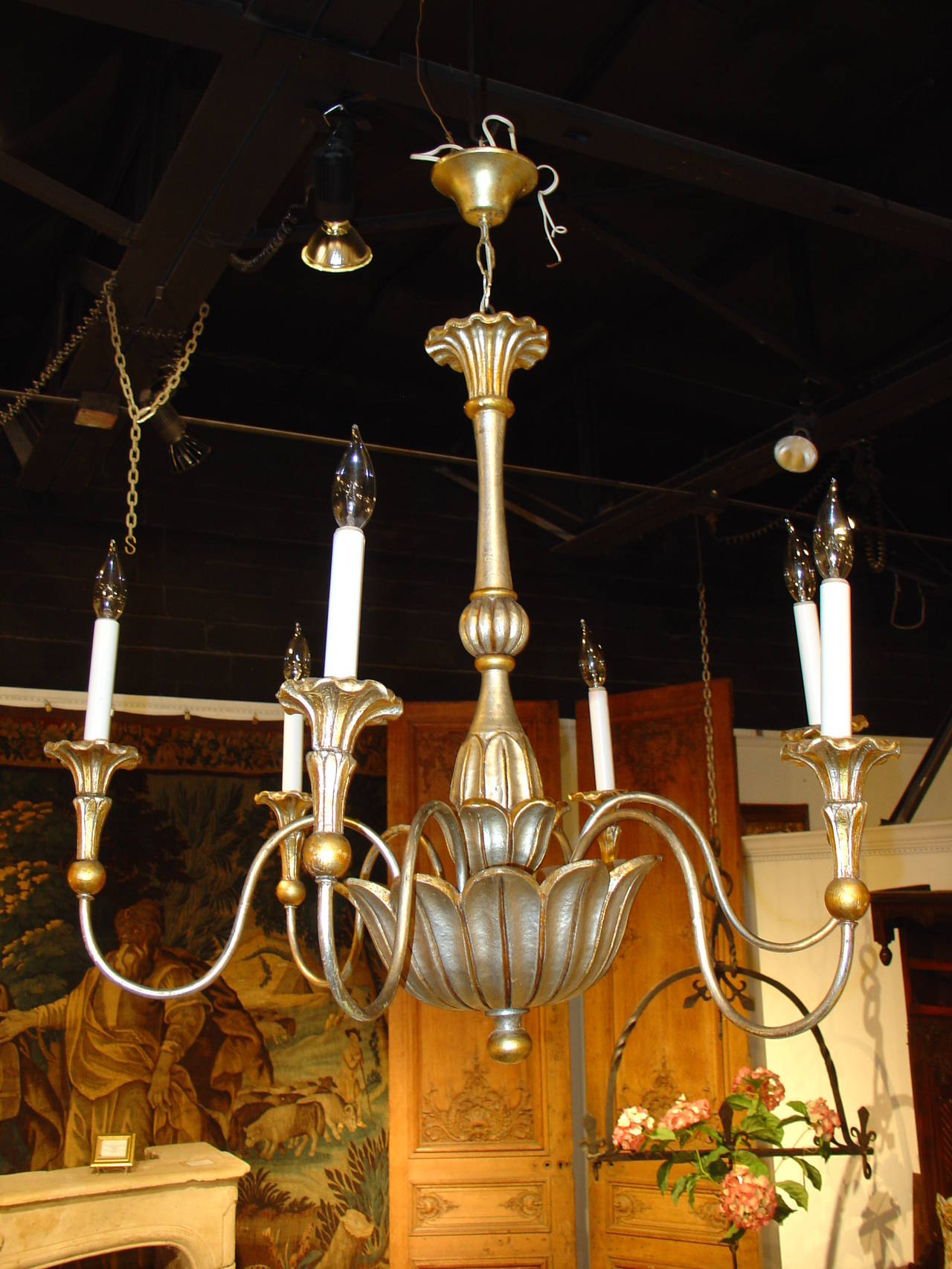 This graceful six arm chandelier combines a touch of nature in its design.  The bobeches are stylized hibiscus flowers while the circular shaped basin features water leaves.  The elegant metal arms are in a s-scroll shape.  Also, the shaft is lobed