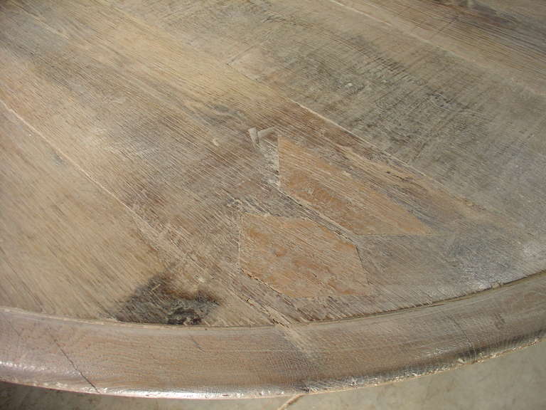 18th century Oak plank top on 19th century cast iron parcel painted base

This large French round table has a scrolling metal base from the mid 1800's, while the top is made of salvaged Oak planks from the 1700's. The beautiful, thick forged iron