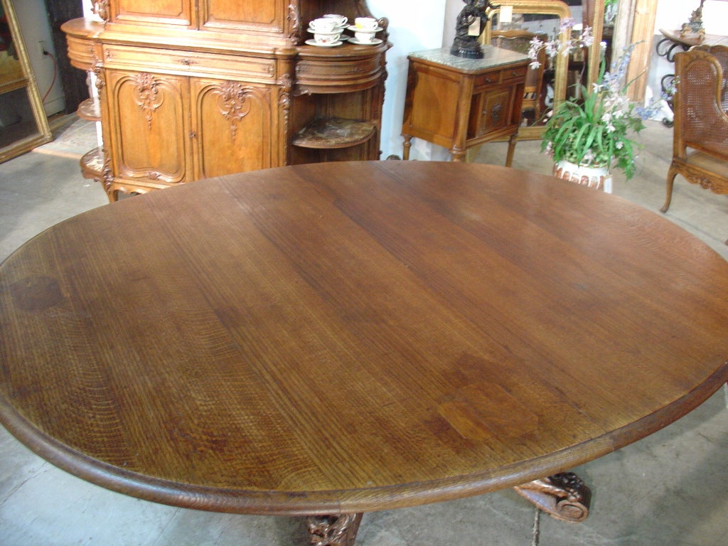 This rare antique French oval extending hunt table has a center pedestal with four legs bearing magnificent hand carved lionsâ?? couchant.  The tables current dimensions in a closed position are 83L x 62-1/4W x 28H.  The table opens at the center