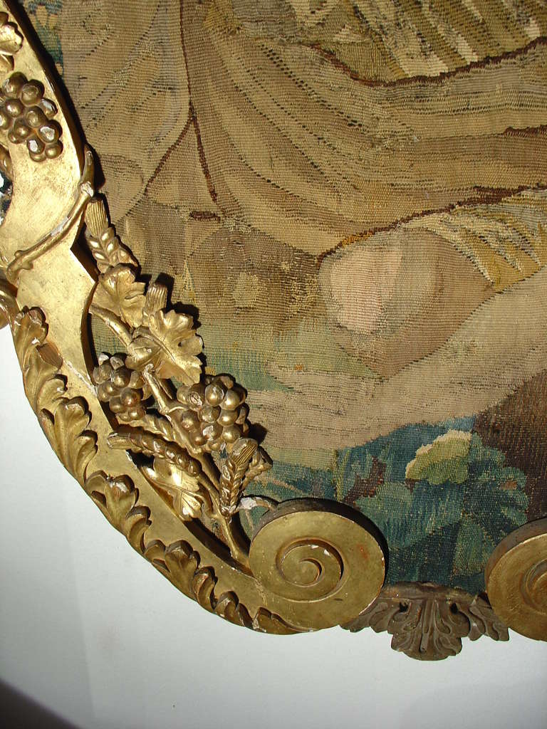 --18th century Aubusson tapestry fragments mounted within 19th century giltwood frame--

This stunning 18th century French Aubusson tapestry fragment depicts a mythological scene with two men at the forefront.  One man who is looking over his