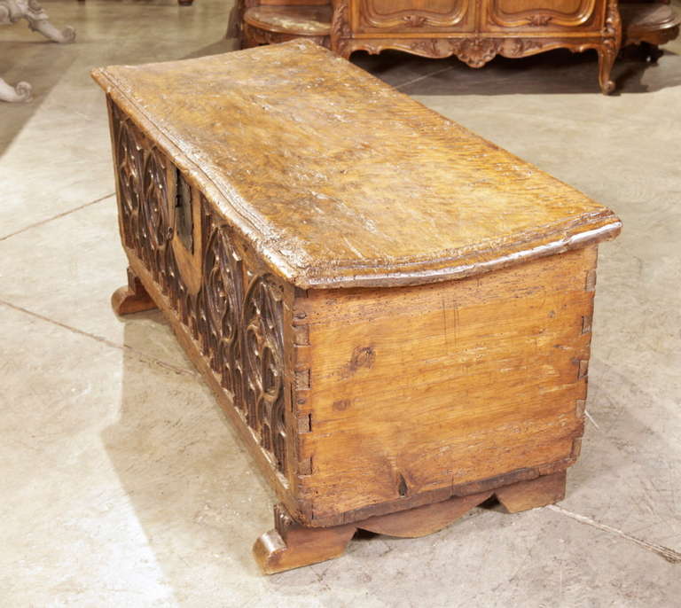 This antique French Gothic style trunk is from the early 1700s.  All of the Gothic motifs on the front have been hand carved out of the beautiful old French walnut wood. The old top, slightly bowed with centuries of people, sitting upon it could