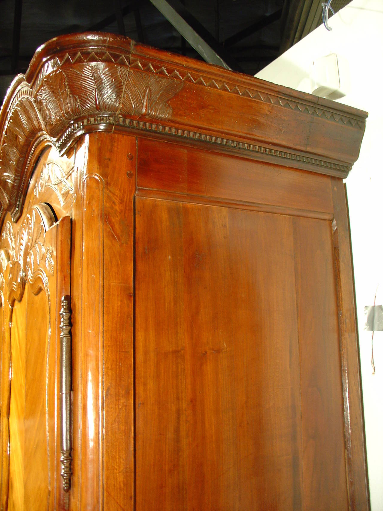 This antique double Chapeau de Gendarme armoire made of cherry wood (and secondary woods) from the area around Rennes, Brittany, France. It has hand carved decorative motifs and it is inscribed with it's created date: L A N 1822 (the year 1822) on