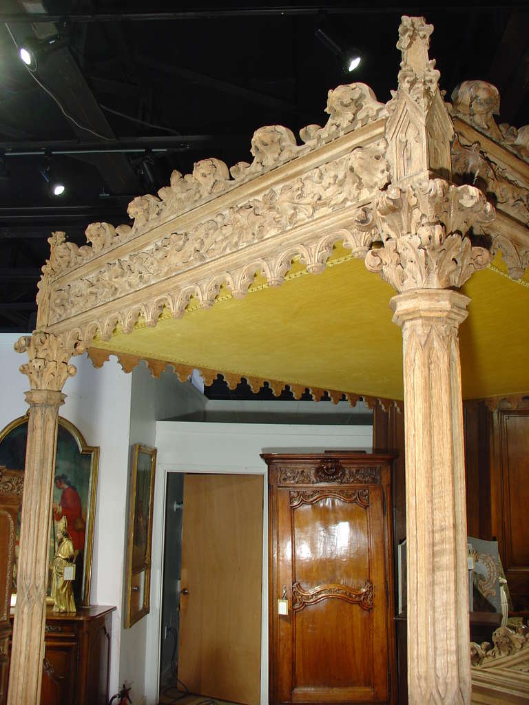 This magnificent antique French Gothic style bed has ornamentation on all four sides and is made from stripped European Oak.   Drapery would have been hung from the inside top frames on all four sides and closed for privacy when needed.  The drapery