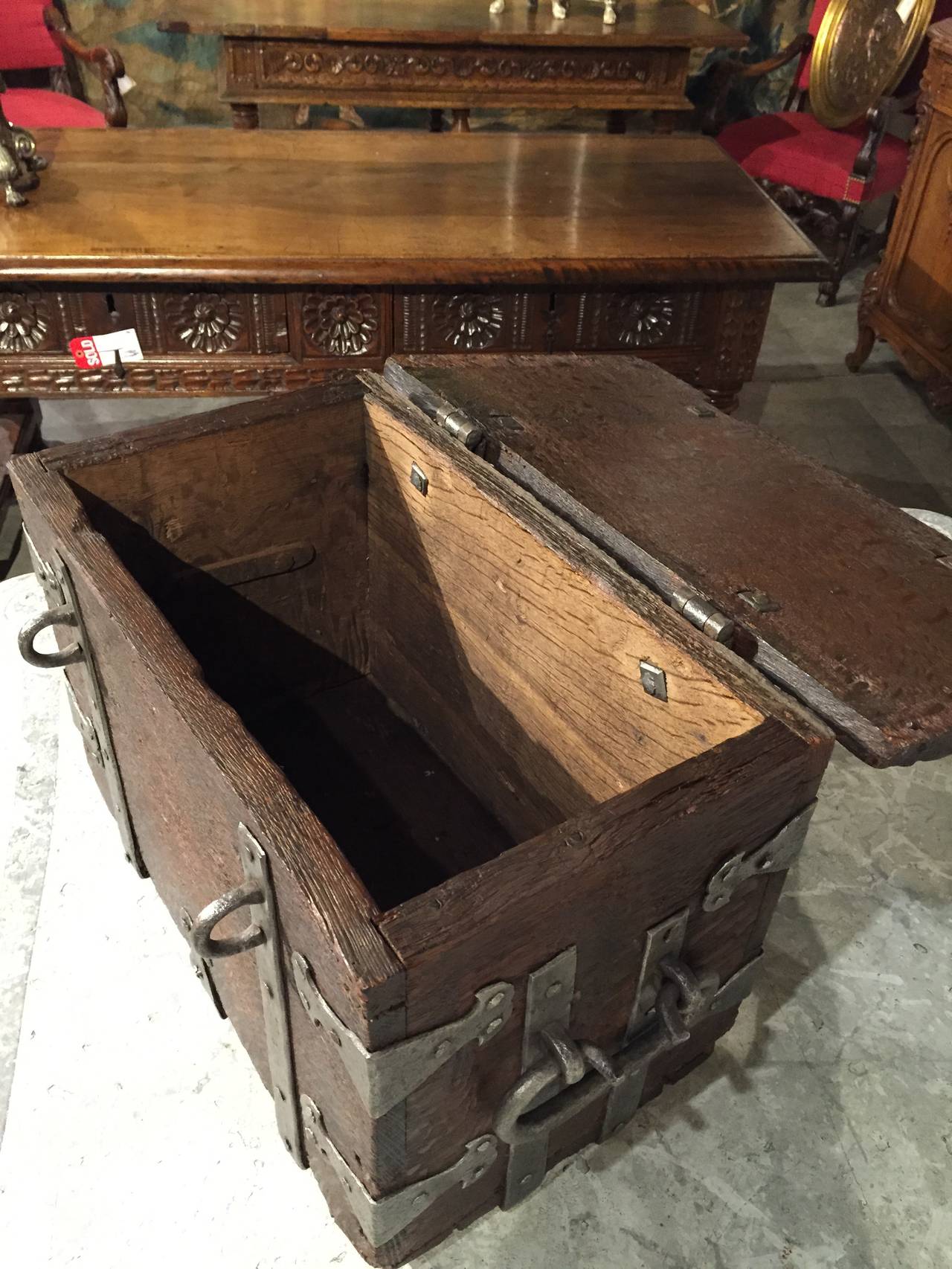 This unique antique French iron strapped wooden, table top trunk dates to the late 1600s. It has wonderful cleaned and polished iron straps with nail heads.  It originally was used as a tax collector’s box by a 