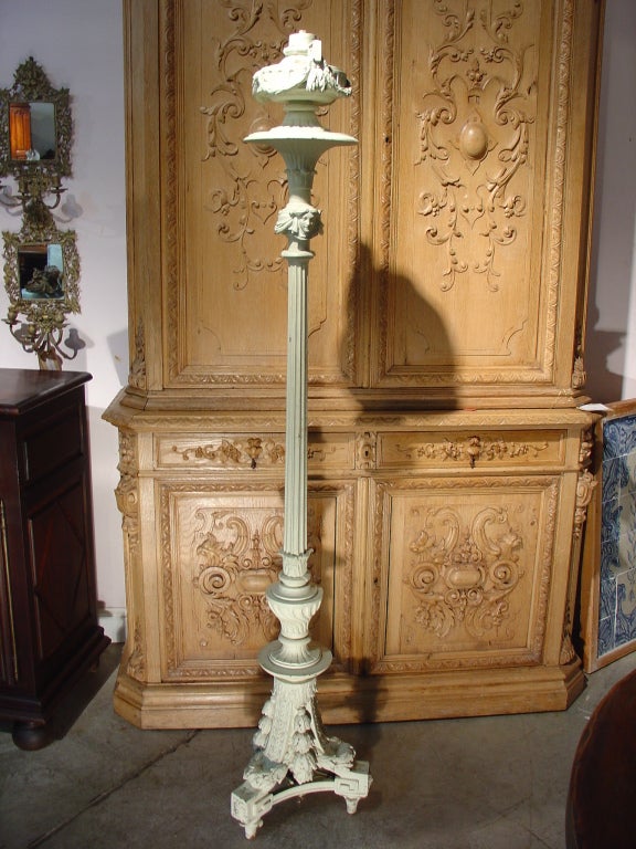 This elegant, antique Louis XVI style painted cast iron torchere can be used inside or out.  Classical, architectural, human faces, and elements of natural derivation are all dominant motifs throughout the entire torchere. The fluted brazier has