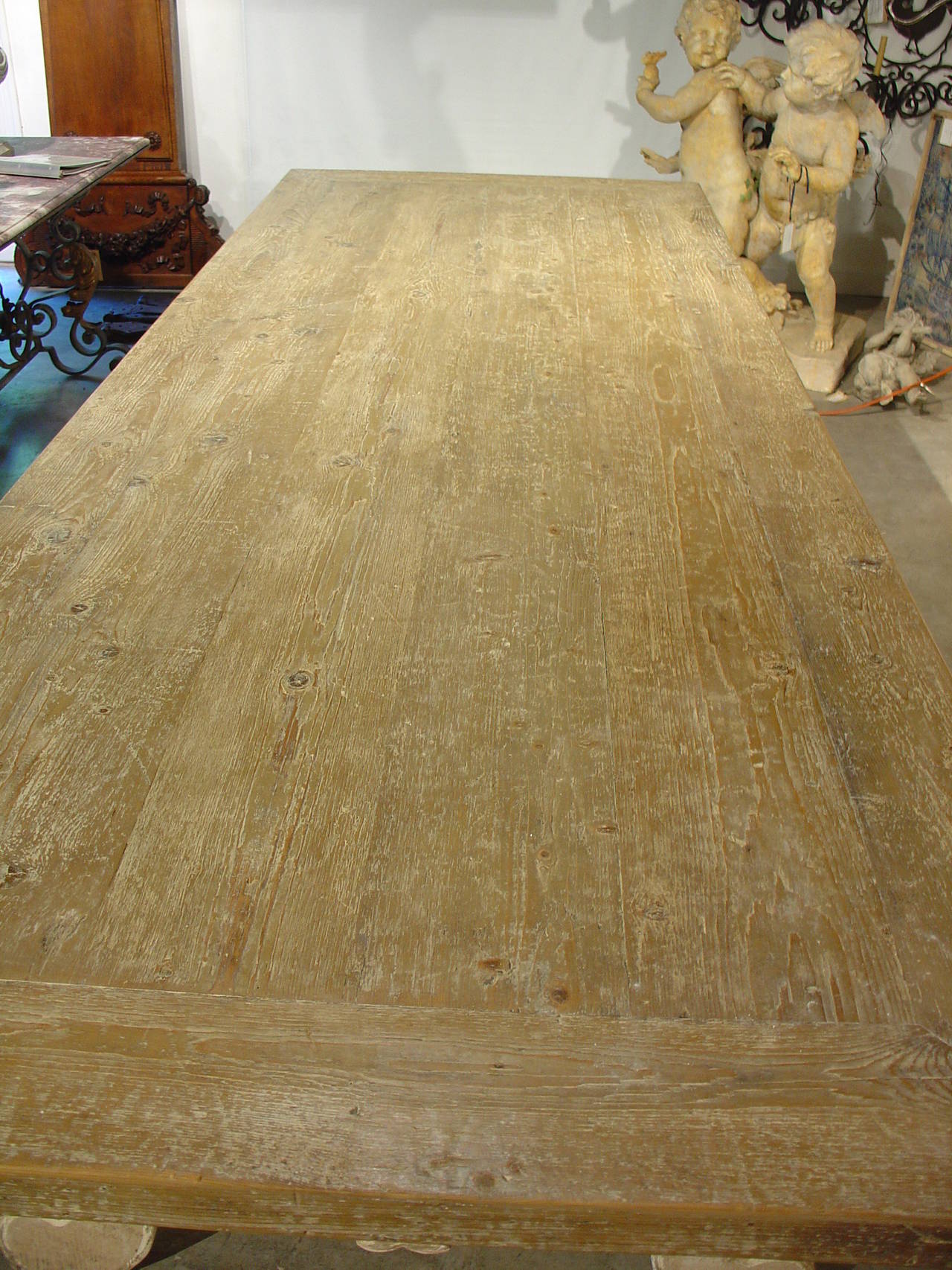This large Italian cerused oak dining table has iron stretchers and lyre shaped legs at either end. The iron stretchers and the shapes of the legs are reminiscent of the Catalan Tables from present day Spain/France. The Italian counterparts often