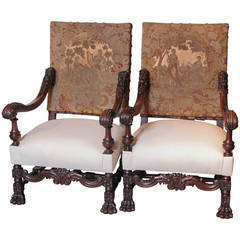 Paire de fauteuils anciens de style Louis XIV en bois de noyer avec pieds en patte de lion