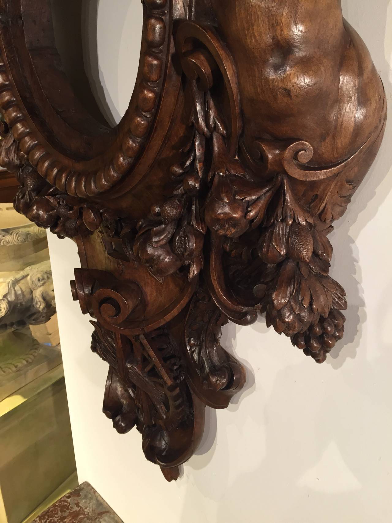 This antique French train station clock surround has been hand-carved from beautiful European Oak. It is in the form of a stylized cartouche. At the very top is a carved bust of the Roman God, Mercury, the swift messenger of the Gods and also the