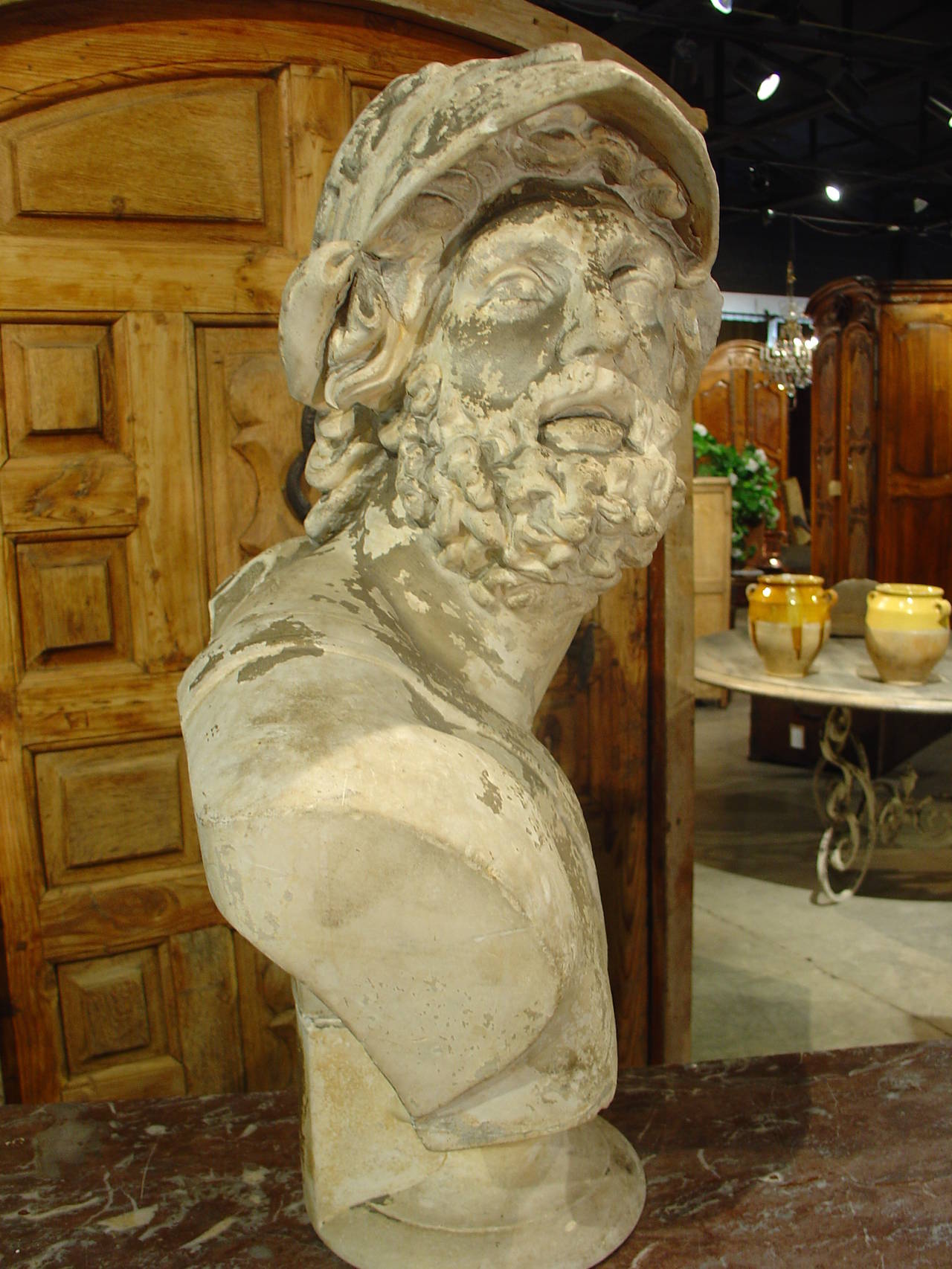 This antique French plaster bust of Menelaus, husband of Helen of Troy was done by a firm in Berlin, Gebruder Micheli, founded in 1824. It is signed and dated 1887 on the back. With its old patination displaying incrustations of chipping paint and
