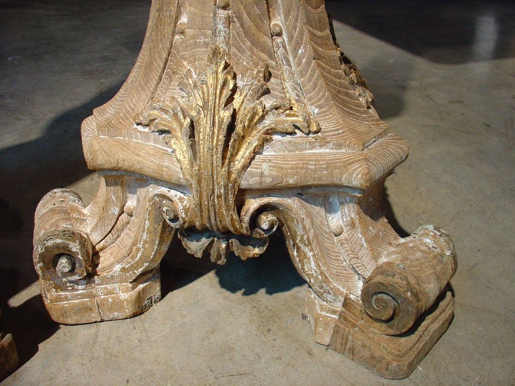 This magnificent pair of tall antique French European Oak torcheres has been stripped at some point in history.  Traces of gesso and gilding are evident  in the carved recesses and on the relief portions of the ornamentation.   The ornamentation is