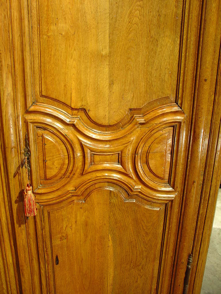 This Period Regence stripped European Oak armoire is typical of the Ile-de-France.  Its ornamentation is elegant with deep curves, assertive moldings and tri-partite front panels having plain fields, which  places emphasize on  the beautiful