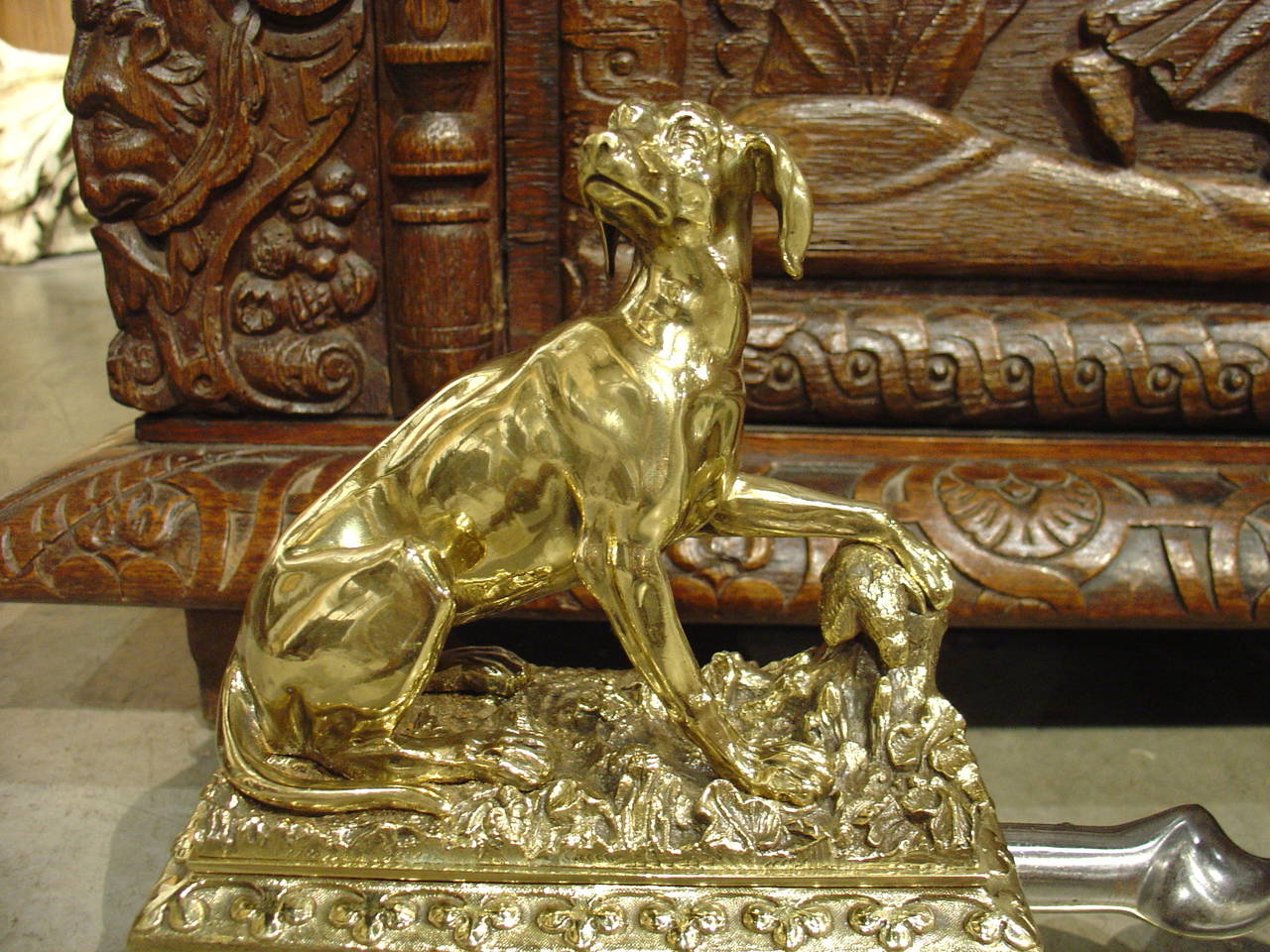 This stunning antique French fireplace fender has been beautifully chased in bronze, brass and polished steel. The dogs are in slightly different seated positions holding down their retrieved trophies with their paws. They are perched atop decorated
