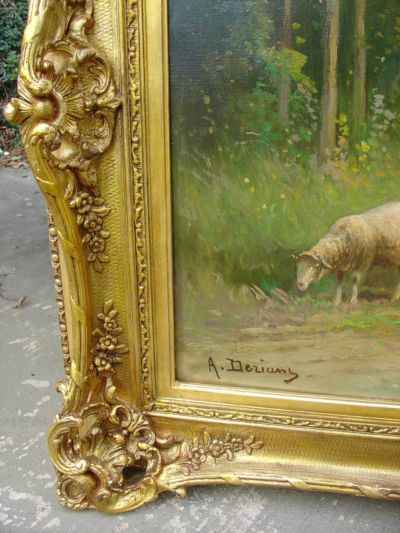 This signed antique French oil on canvas painting (signed lower left A. Derians) depicts a peaceful pastoral scene featuring a sheepherder, his flock, and his dog. They appear to be in a pasture following a somewhat worn path surrounded by trees on