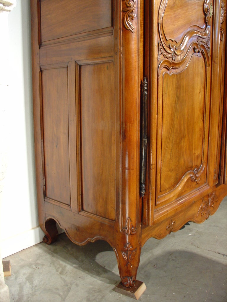 This magnificent blonde walnut wood armoire from the Vallee du Rhone is from the mid 1700’s during the Louis XV period.  During the reign of Louis XV, asymmetry in furniture lines was all pervasive, with curved lines softening forms and motifs.