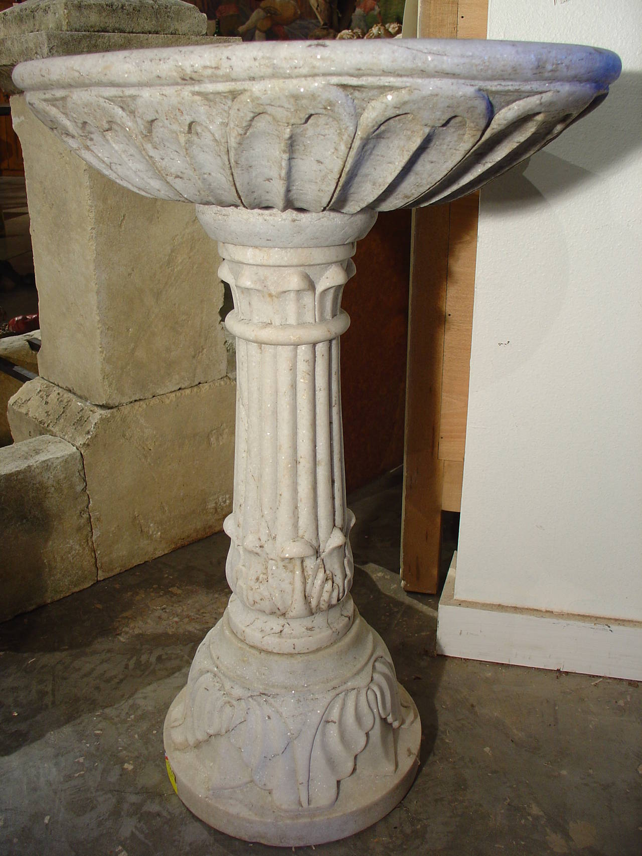 This elegant antique French marble pedestal sink comes from a quarry with varying degrees of white and pale grey tones with brown veining.  The sink’s interior has deep fluting replicating the inner portion of a shell, and there are two lobes