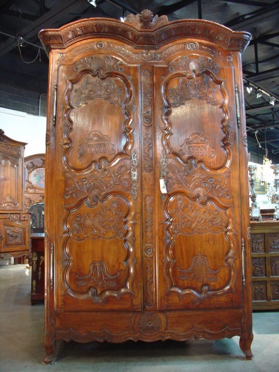 This highly carved and incised antique armoire in Cherrywood is from Rennes in Brittany, France.   The country cabinetmakers in and around Rennes often signed and dated their furniture.  There is no other region in France where the signature on the