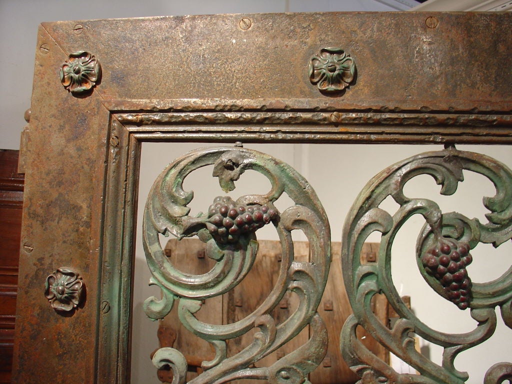 An Antique French Metal and Cast Iron Wine Room Door with Grape Cluster Motif; Condition: Interior glass window and frame missing, but hinges and latch are in place - no key – Rusting, rubs and nicks to exterior surface – One grape cluster missing –