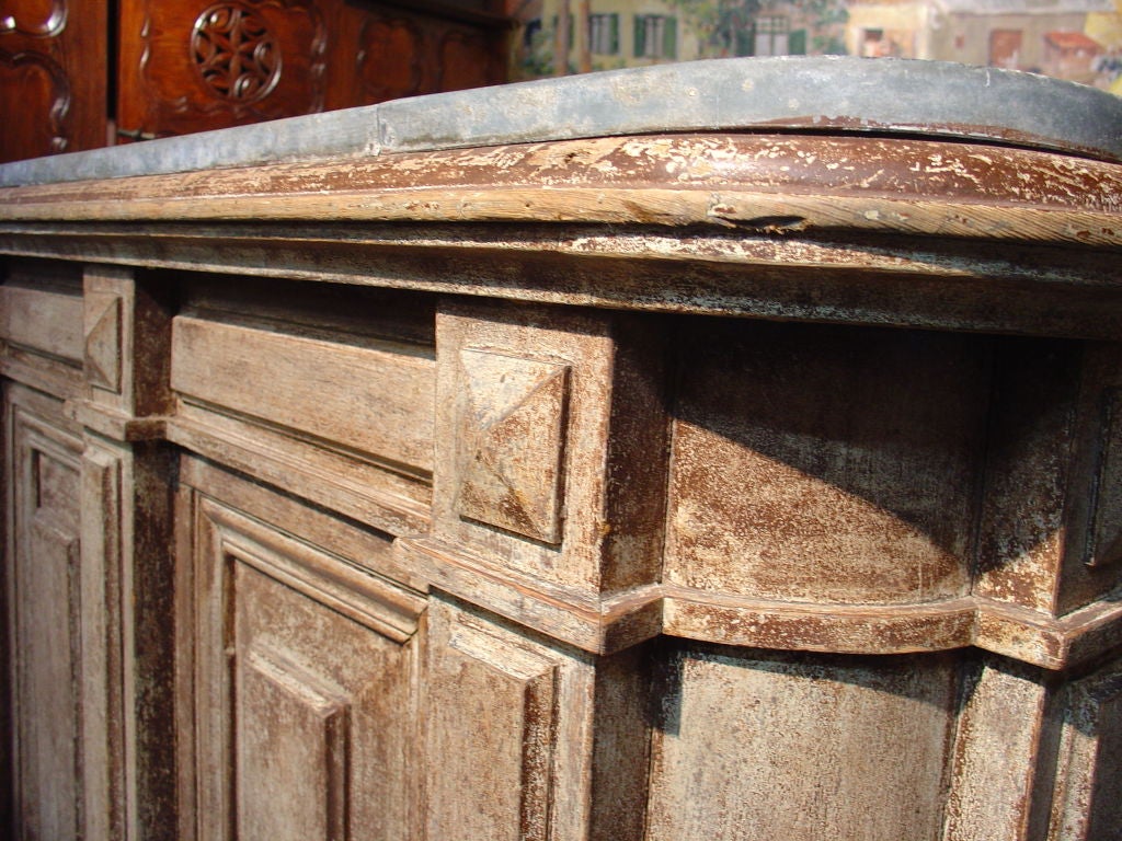 Northern France, Late 1800s<br />
<br />
 This antique French island counter has a sink with bronze faucet and zinc top.  Geometric in its design, with simple rectangular raised beveled panels and pilasters with diamond point capitals, it blends