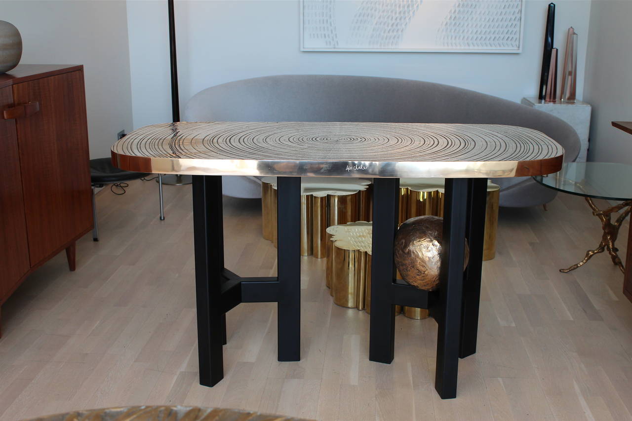 'Goutte d'Eau' console in cast bronze on black lacquered metal feet.
One foot holding bronze sphere sculpture.