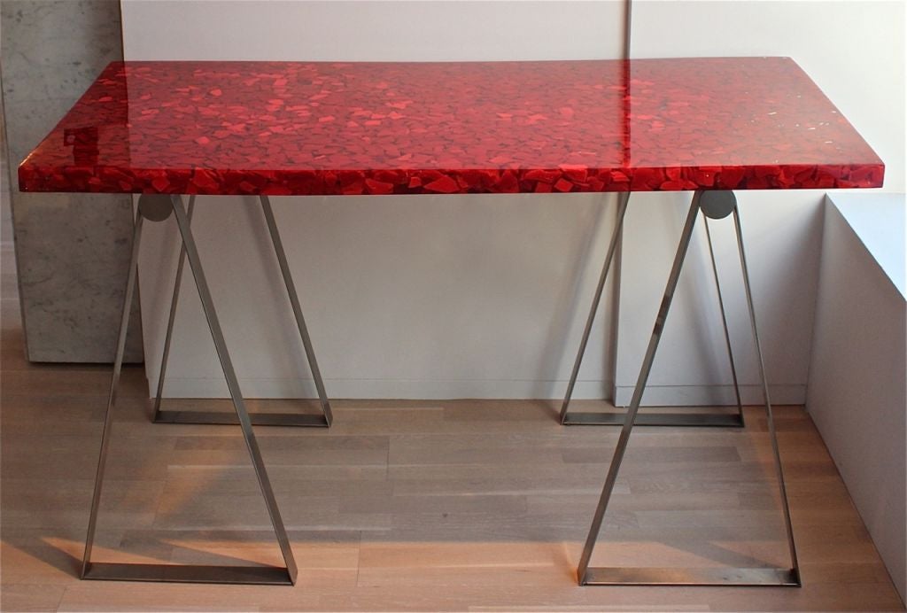 Desk/Console with a top of red and clear resin on brushed steel trestle legs by Jean Brand for Atelier Janus.

Bears the monogram of Atelier Janus on the edge of the top.