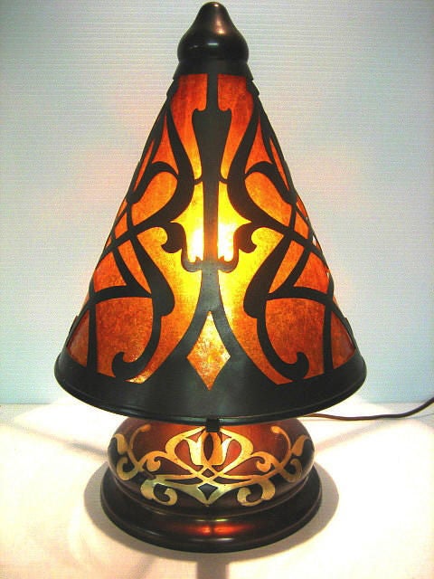 Unique form in ROYAL (iridescent red) patina with mica-lined exaggerated conical shade. Cutouts in shade mirror sterling overlay on squat base. Tastefully rewired with repro fabric-wrapped cord.