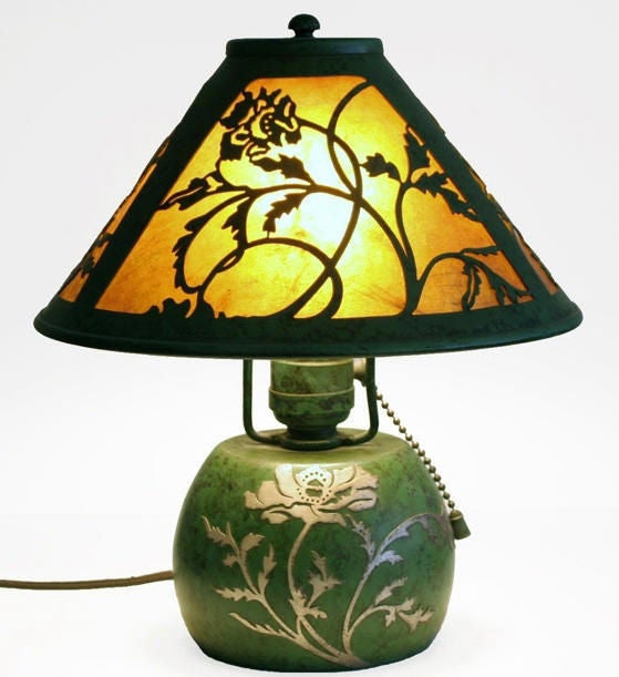 Boudoir lamp in vivid variegated green patina sports sterling overlay of a poppy. Cutout work of poppies in mica-lined shade varies slightly in each panel. Tastefully rewired in repro fabric-wrapped cord.