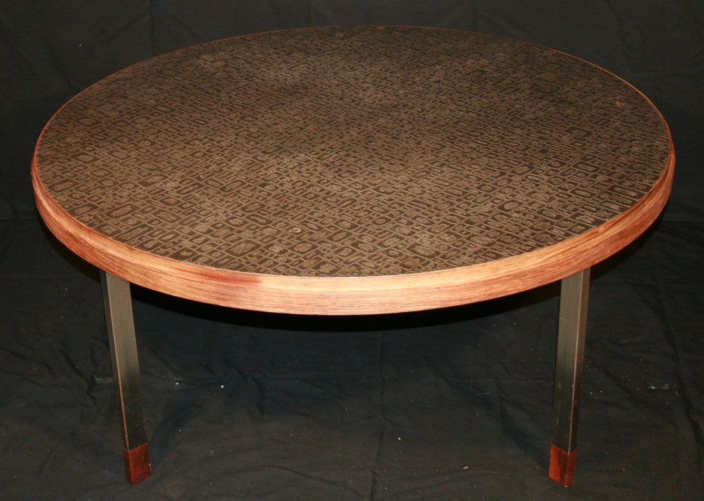 Round coffee table etched in steel to give an impression on embedded mozaiques.