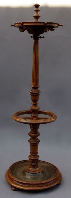 Oak coat rack with umbrella stand, standing on a circular base with a metal basin for rain water. The central part is made of a column with a fluted upper part. Coats can be hung up on hooks.
Work from Napoléon III period.
