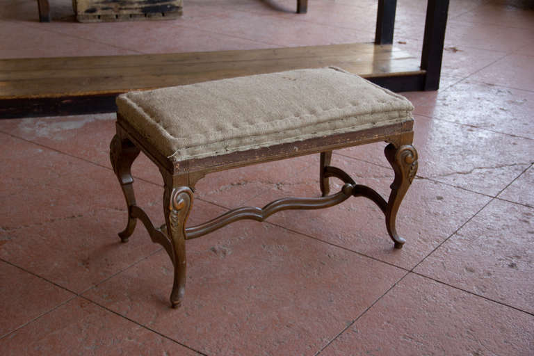 Louis XV style antique French stool with hessian upholstering.  The stretcher connects the four legs.