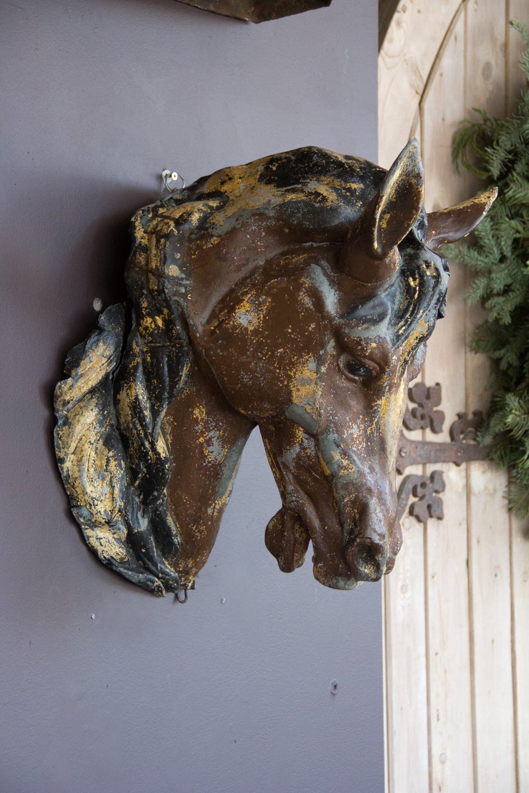 This is a stunning example of an original antique gold gilt and paint over zinc French horse head. He leans slightly to the left, which allows the teeth and tongue to be visible.

The head would have hung above a butchers shop 