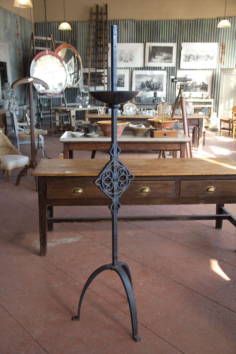 Antique wrought and cast iron French chapel candle stand on a splayed tripod base.