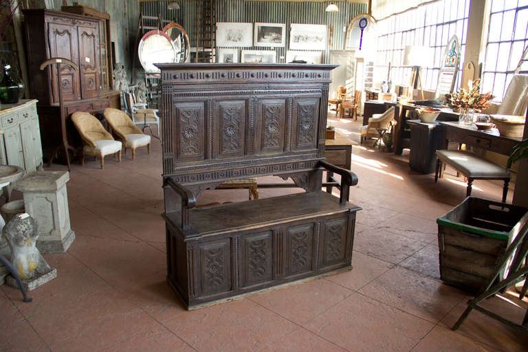 Antique Jacobean style English oak box settle with high back and carved panels.  Seat lifts for storage.
