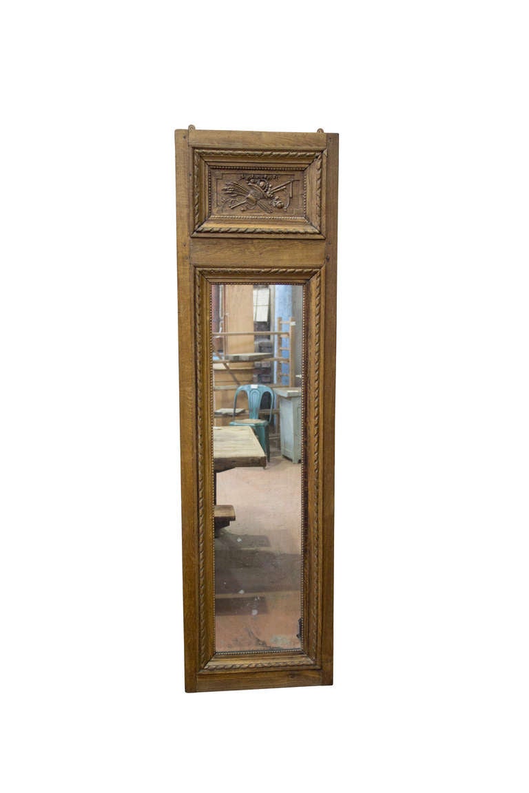 All original 18th Century simple country style French Louis XVI oak bevel mirror. The upper panel carving of a harvest basket is beautifully carved. Lovely aging to the original glass.