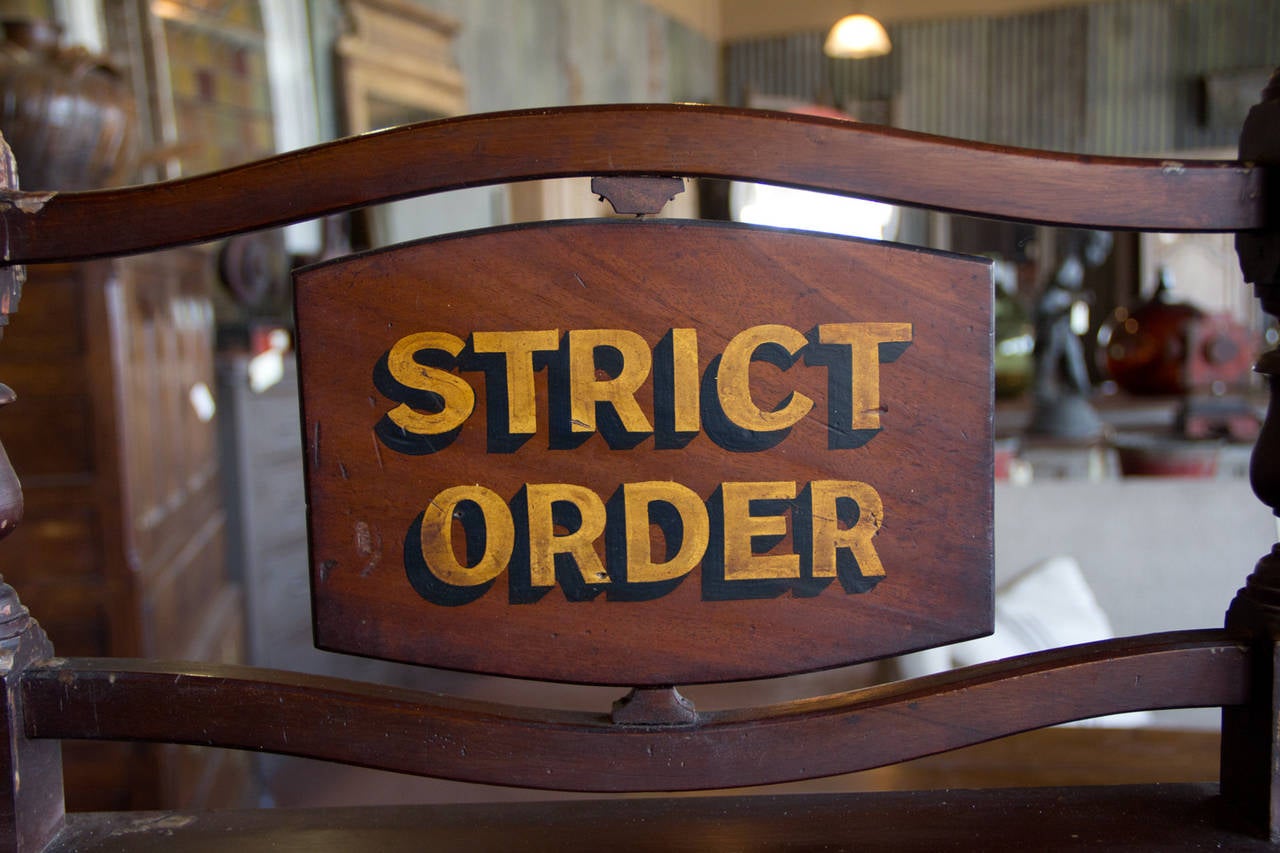 A very unusual mahogany antique slope top clerk's lectern. It has a pair of candelabrum to the top. The desk top lifts for storage and it also has a single drawer. The swing sign reads 