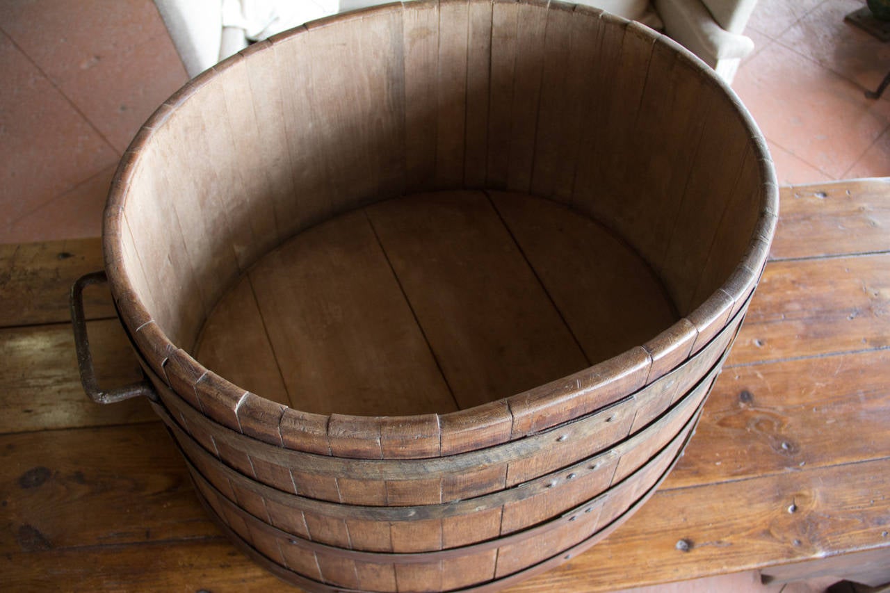 Antique French oak wine harvesting barrel with hand-wrought handles and riveted strapping.