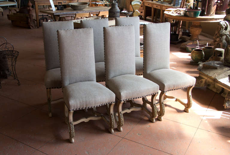 This is a stunning set of 6 vintage Os de Mouton dining room or side chairs. They have been restored and reupholstered in beautiful grey linen and brass studs. The legs are unusual with wonderful scrolling and acanthus leaves.