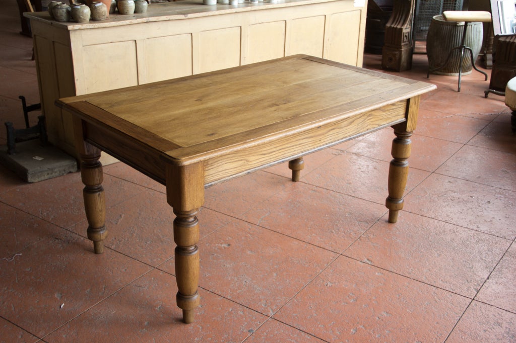 Beautiful antique English school desk with turned legs and fine beaded trim along the skirt. The wood in the centre of the table has been replaced with reclaimed oak planks.