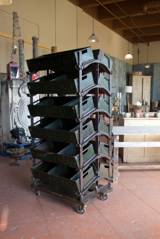 This fabulous heavy vintage double sided racking unit holds 12 original metal storage containers. It is on wheels for easy maneuvering. It was salvaged from an old garage and used to store vehicle parts.  A very funky and useful piece!