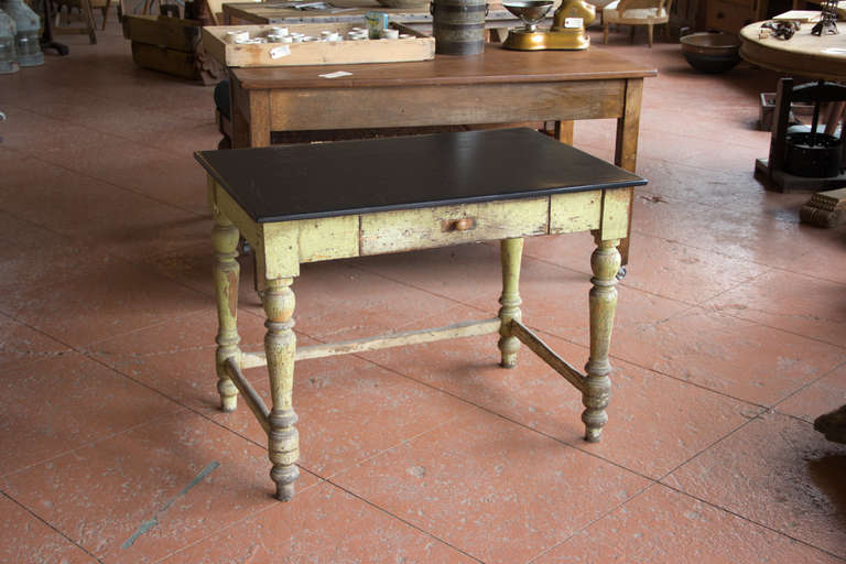 Antique English pine dovetailed desk with Victorian turned legs and centre drawer. It has its original paint and the top has been replaced with a slab on 19th century Welsh slate. The combination of the painted pine and slate is beautiful.
