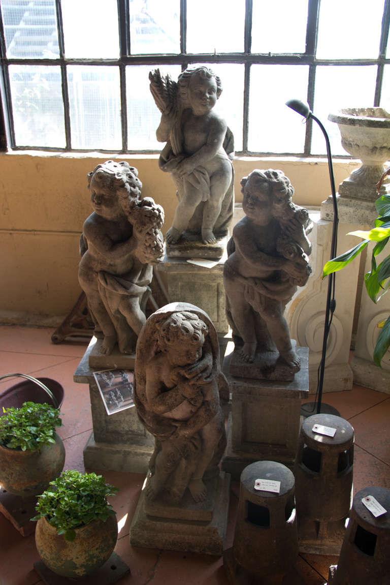 Set of 4 English vintage composite stone Four Seasons putti with associated stone plinths and lintels which came from an orangery in Bushy Heath, Herts, UK