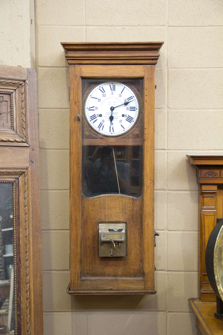 Antique factory clock patented by Arthur Lambert at Saint-Nicolas Aliermont, Normandy. The case is oak and the clock face is enamel over copper with Roman and Arabic numbers. It was used for factory workers to clock in and clock out.