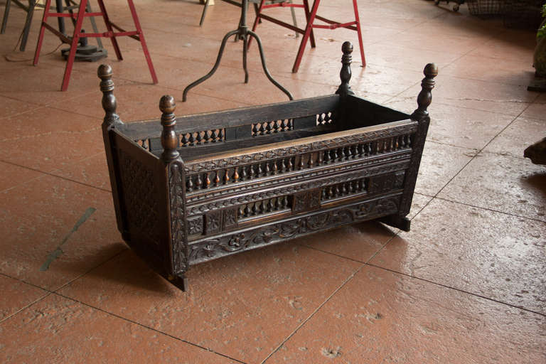 This is a beautiful antique oak cradle made in the Tudor style. The colour is gorgeous and the workmanship is stunning.
There are little gnaw marks on the top of the finials indicating that this was used by a child! 

We don't think it is a 17th