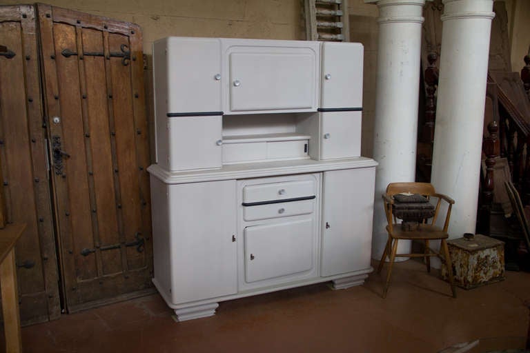 Traditional French Art Deco step back kitchen dresser with 8 cupboards, 2 pull out drawers, one slider drawer and plenty of shelves. It has it's original hardware and a newer paint job of stone white and slate grey.

Wonderful authentic features