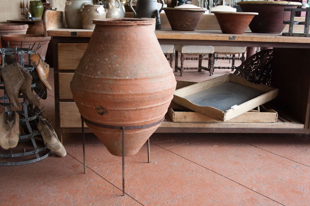 19th century (or possibly much earlier) Turkish hand thrown terra cotta olive jar set in a   wrought iron stand.