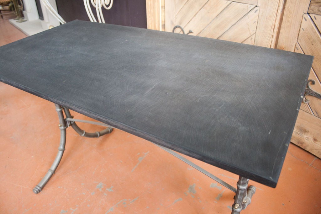 Unusual faux bamboo cast iron table base of high quality.  The detail is lovely with brass bolts and registered trade mark visible on bar.  The base is topped with a beautiful slab of Welsh slate.<br />
We have 4 tables available.