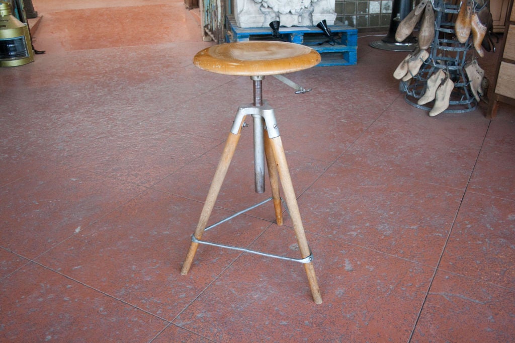 Vintage architects wooden adjustable swivel stool with metal accents and triangular shaped foot rest.