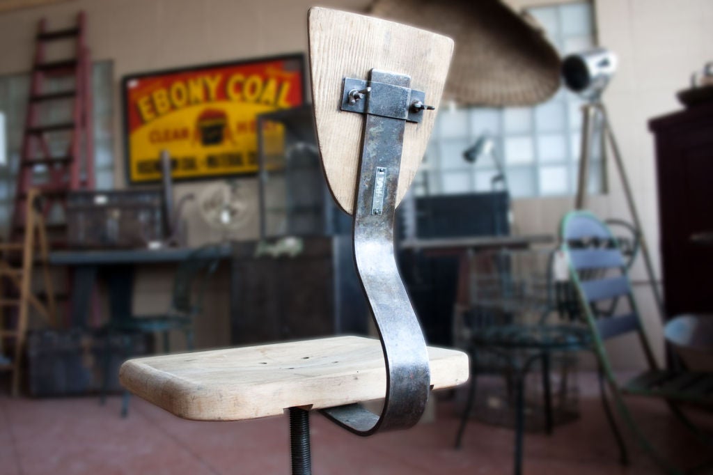 Vintage industrial 3-legged machinist chair from the Czech Republic.  It has it's original plywood backrest.  The wooden seat has at some point been replaced.<br />
Seat 16 in wide x 13 in deep